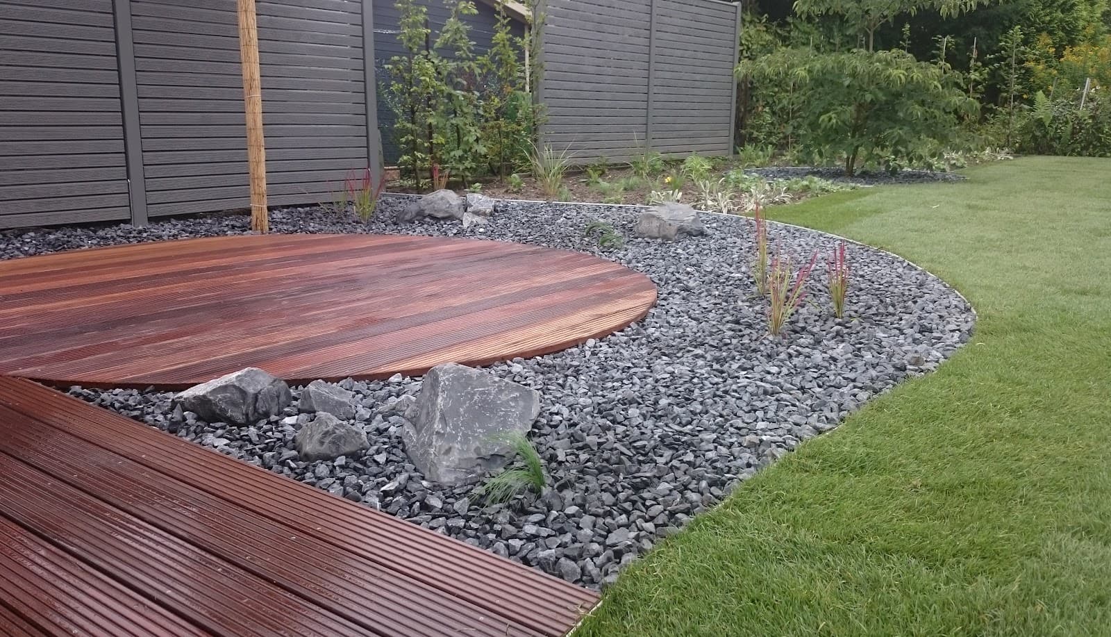 Runde Holzterrasse mit Splittbeet und Sichtschutzzaun